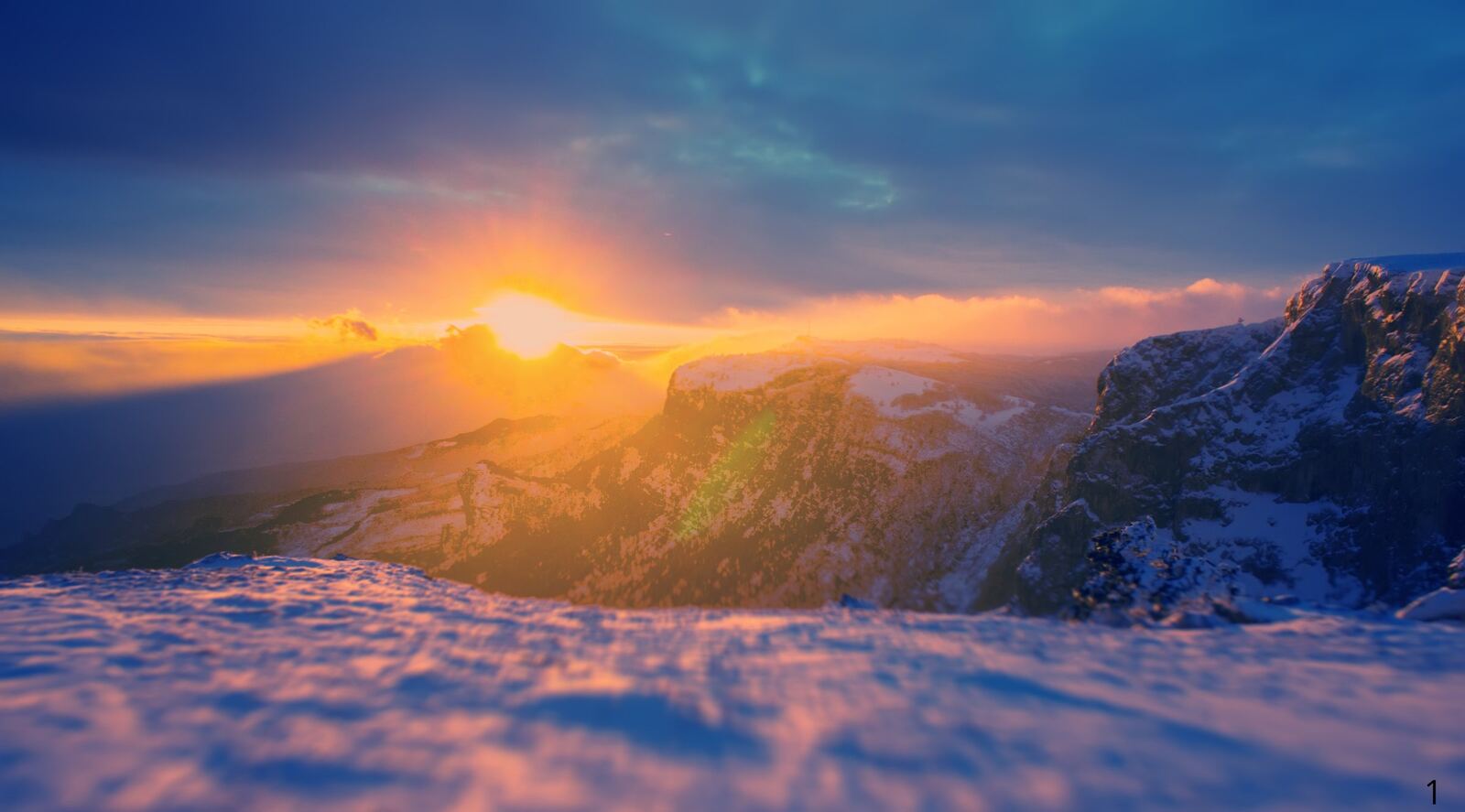 Lever de soleil sur un massif montagneux enneige